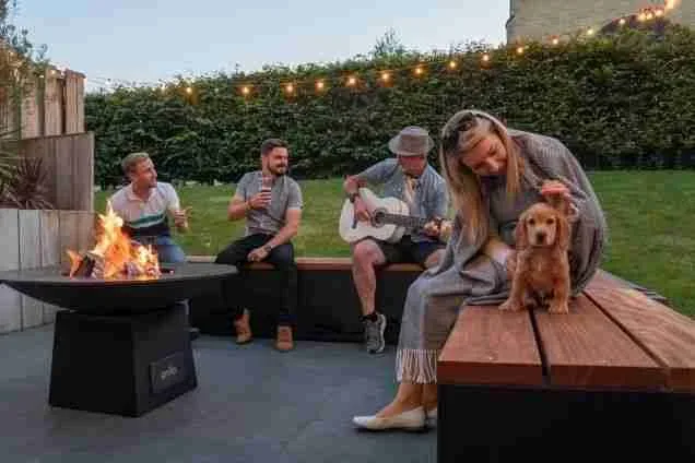 people sitting on grillo kitchen bench seating around a short chefs anvil