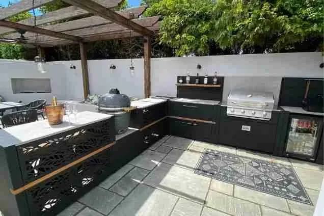 L-shaped outdoor kitchen on patio on the South Coast in walled garden