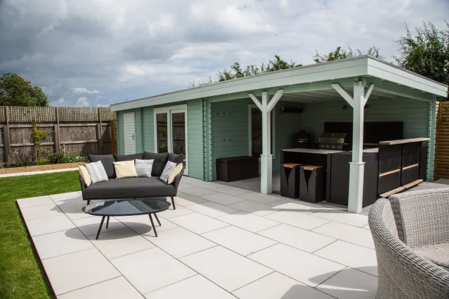 outdoor kitchen under roof of summerhouse with seating area in Warwickshire