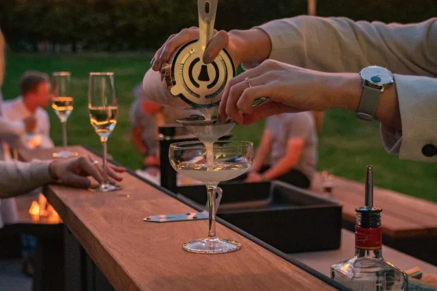 outdoor kitchen bar with cocktail being poured on the iroko wood