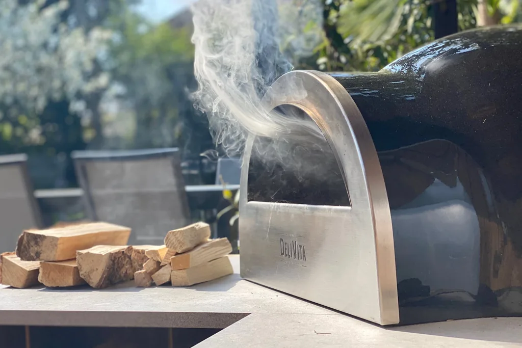 outdoor kitchens with pizza ovens close up of a smoking Delivita pizza oven