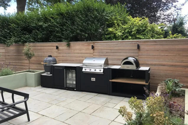Outdoor kitchen in crystal palace, london on patio with garden lights behind