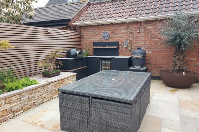 L-shaped outdoor kitchen with dining table on patio in Mountsorrel, Leicestershire