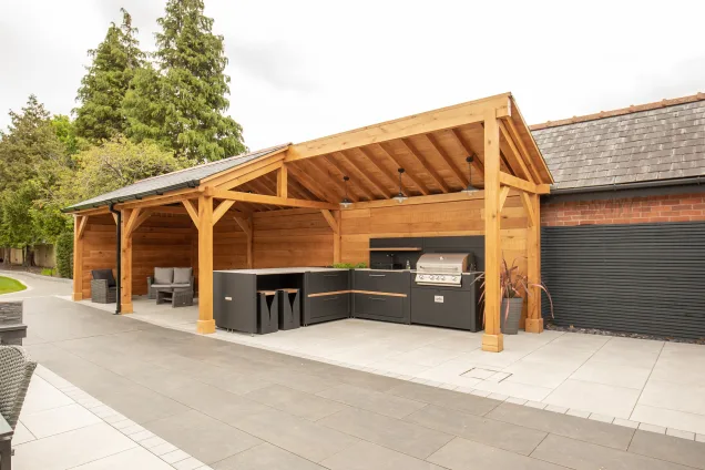 Outdoor kitchen in Cheshire under wooden pergola on patio with gas bbq