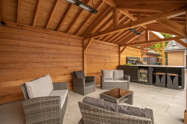 Outdoor kitchen in Cheshire under wooden pergola on patio with drinks fridge