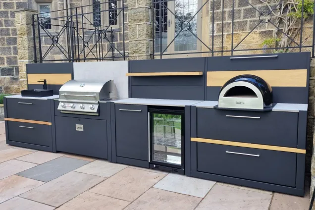 Outdoor kitchen in Ilkley, Yorkshire with bull bbq, pizza oven, fridge and sink on patio