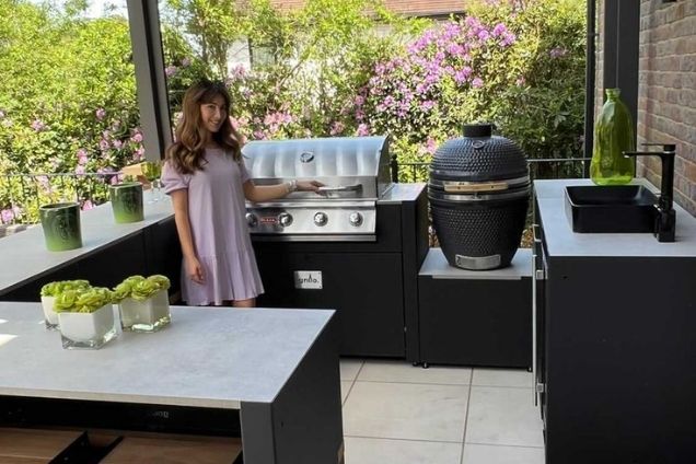 Outdoor kitchen in Tadworth with bull gas bbq and gusto bbq under pergola with woman standing at bbq