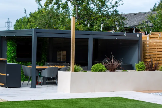 Outdoor kitchen in Leicestershire under pergola in landscaped garden with plants and patio