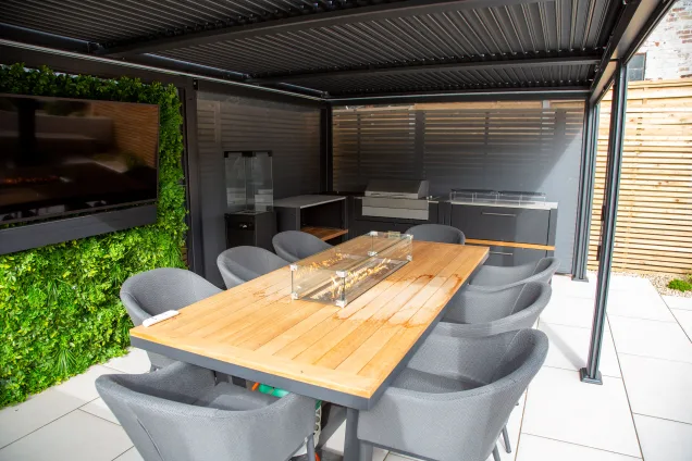 Outdoor kitchen in Leicestershire under pergola with dining table and electrc bbq