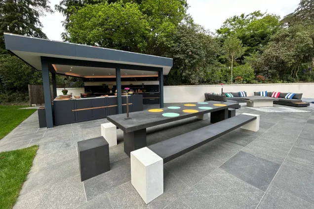 Outdoor kitchen under pergola in Farnham on patio with dining table