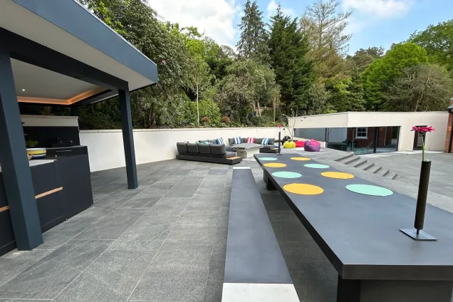 Outdoor kitchen under pergola in Farnham with wood fired pizza oven and bull gas bbq and outdoor dining table