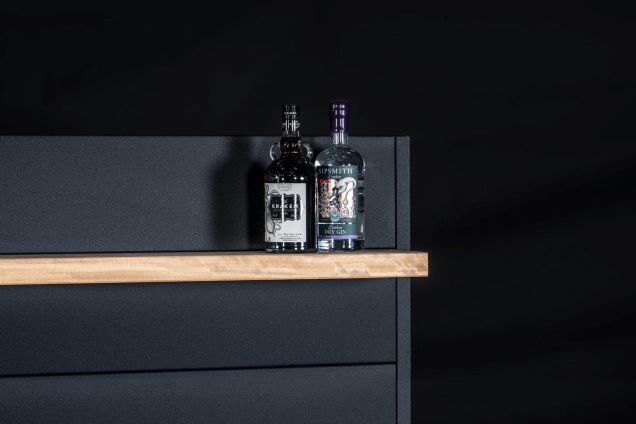 Outdoor kitchen feature wall with bottles on shelf