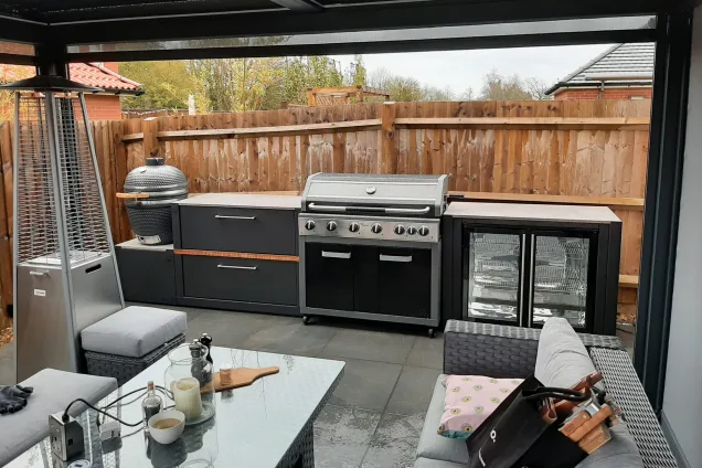 outdoor kitchen on patio under pergola with double fridge and grillo gusto charcoal bbq