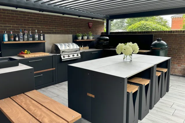 outdoor kitchen under pergola with gas bbq, outdoor seating and bar and bench seating