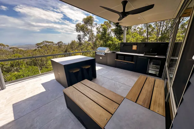 Outdoor kitchen with bench seating, bar seating, bull gas bbq and storage and fridge and bin