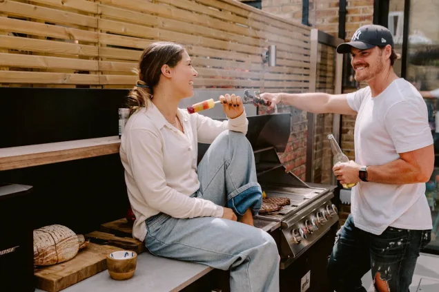people enjoying using outdoor kitchen and gas bull bbq