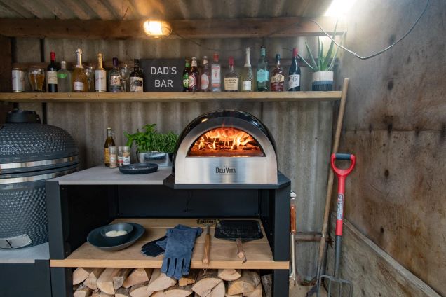 small outdoor kitchen with gusto charcoal bbq and pizza oven and storage cabinet