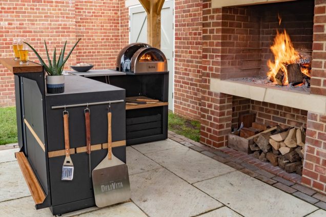 outdoor kitchen on patio with open fire in large garden