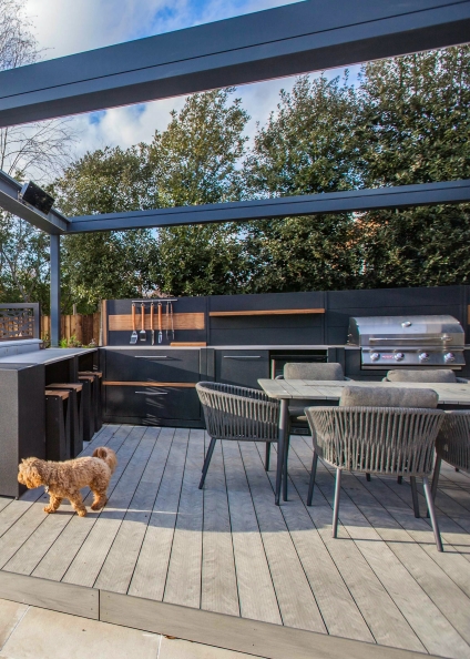 outdoor kitchen under grey pergola on decking