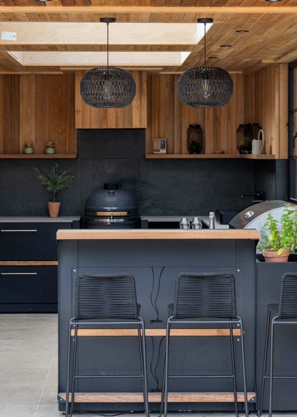 outdoor kitchen in a garden room with bar stool and wooden features