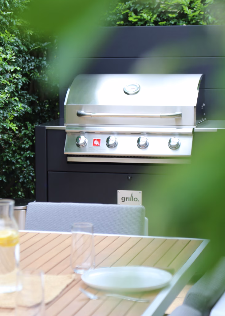 outdoor kitchen in garden with gas bbq and outdoor table