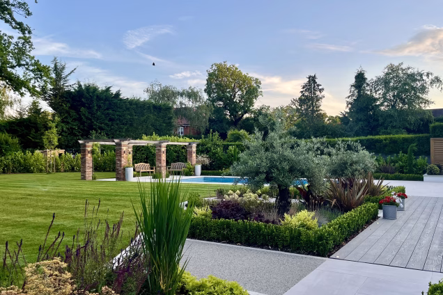 large garden with lawn, outdoor pool, planters and decking
