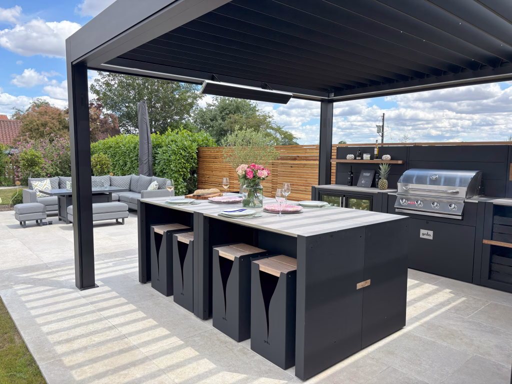 A Grillo outdoor kitchen under a pergola, featuring a bar seating island with 8 Grillo Blaze bar stools