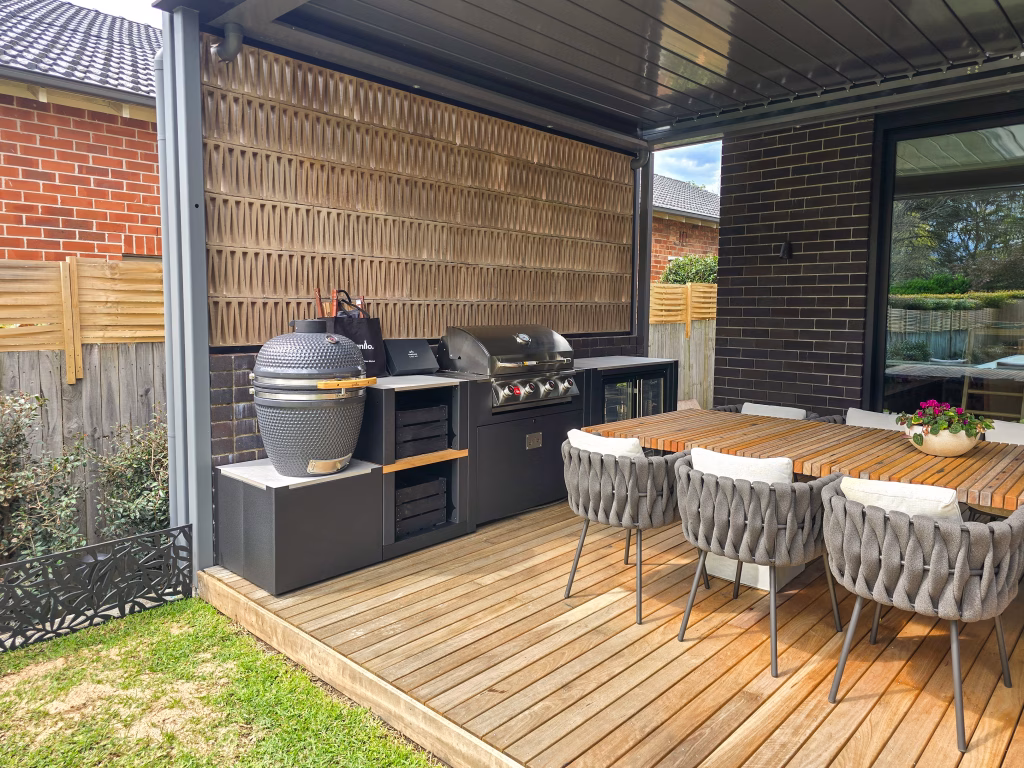 outdoor kitchen on wooden decking under pergola with gusto charcoal bbq, bull gas grill and storage