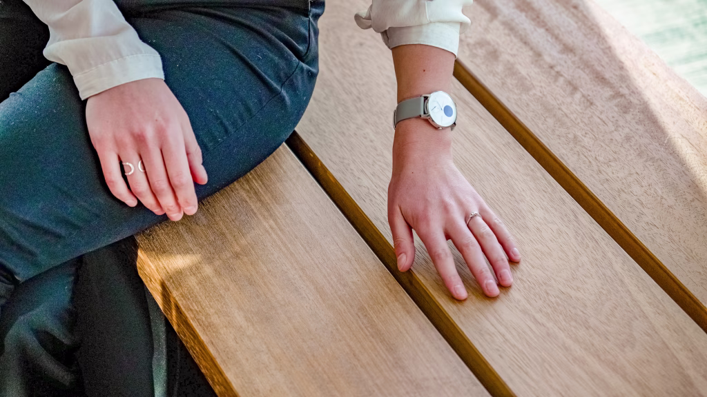 Closeup of a hand touching smooth planed iroko staves atop the Vantage Bench seating
