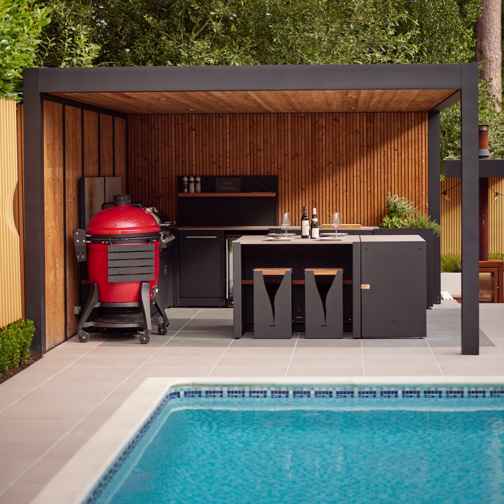 sleek garden with large pool, red bbq and outdoor kitchen under pergola