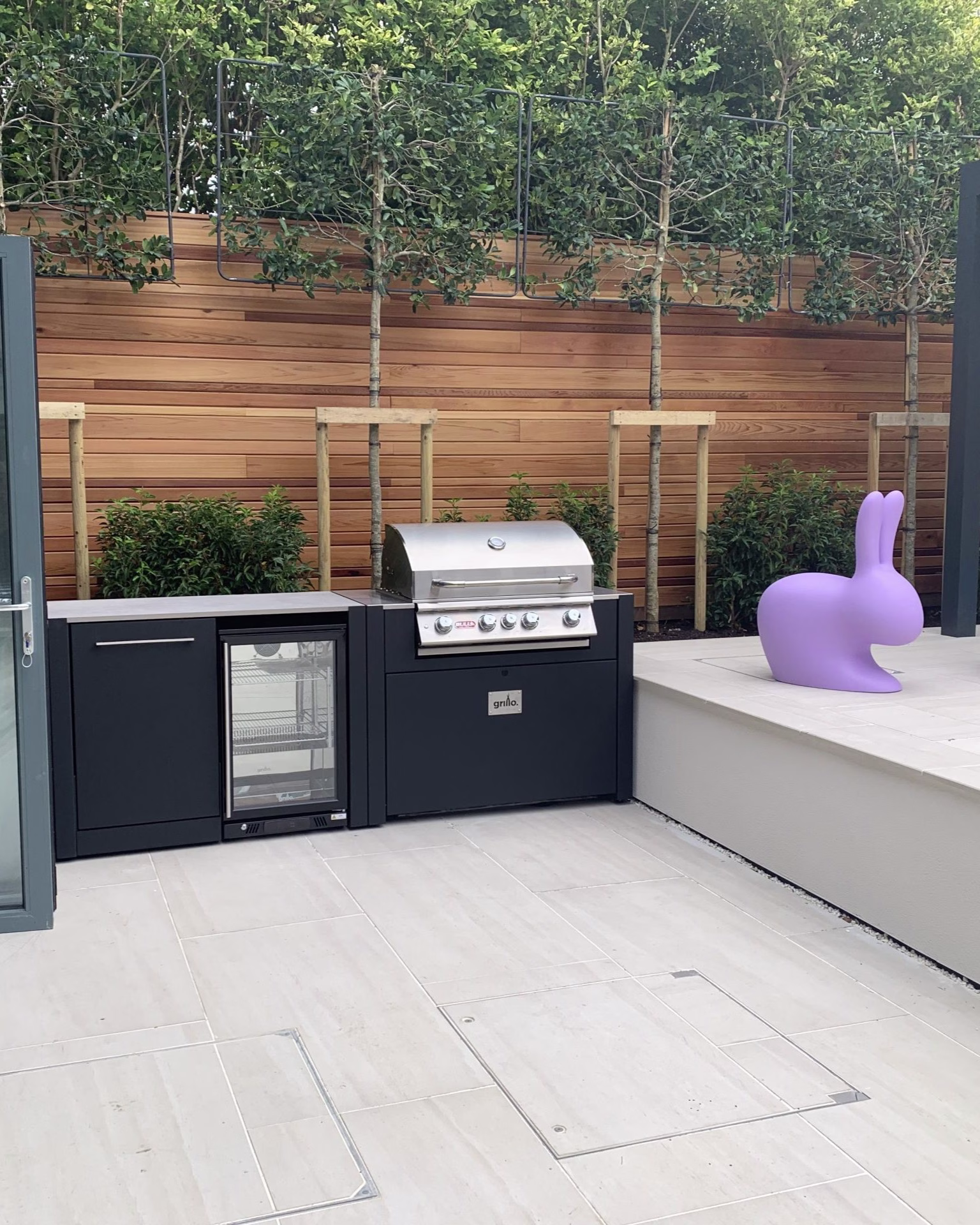 outdoor kitchen on patio with bull gas grill station and drinks fridge and bin