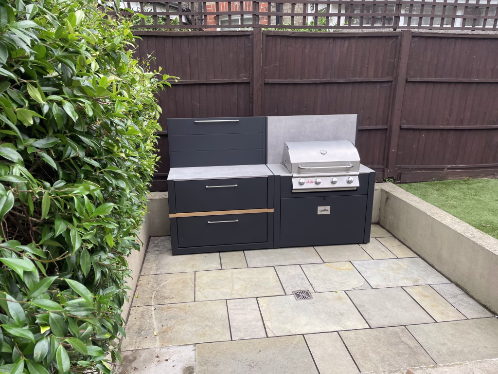 outdoor kitchen on patio with storage cabinet and feature wall and bull gas grill station
