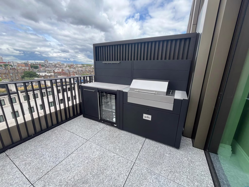 Outdoor kitchen with electric bbq and drinks fridge and bin on patio