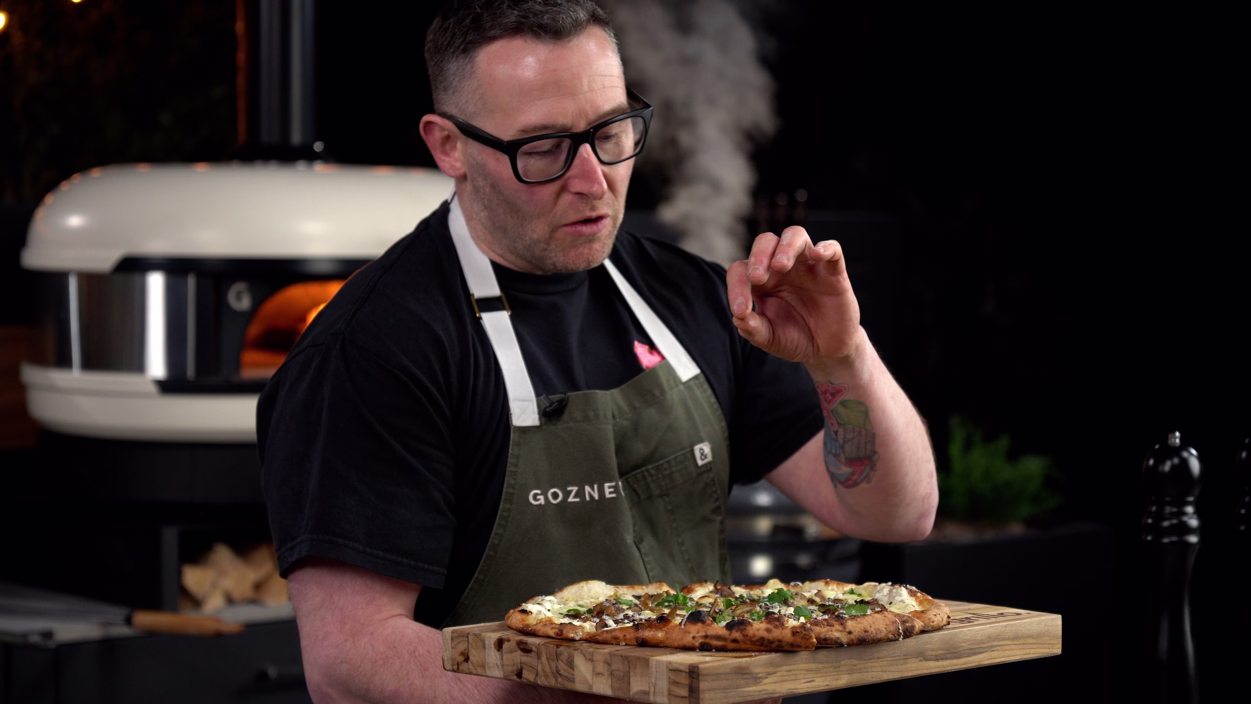 adam atkins presenting pizza cooked in grillo kitchen