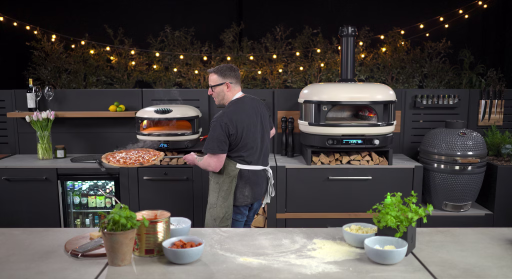 outdoor kitchen with person cooking pizza