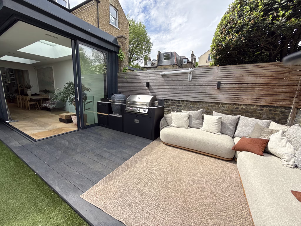 outdoor kitchen next to seating area on patio